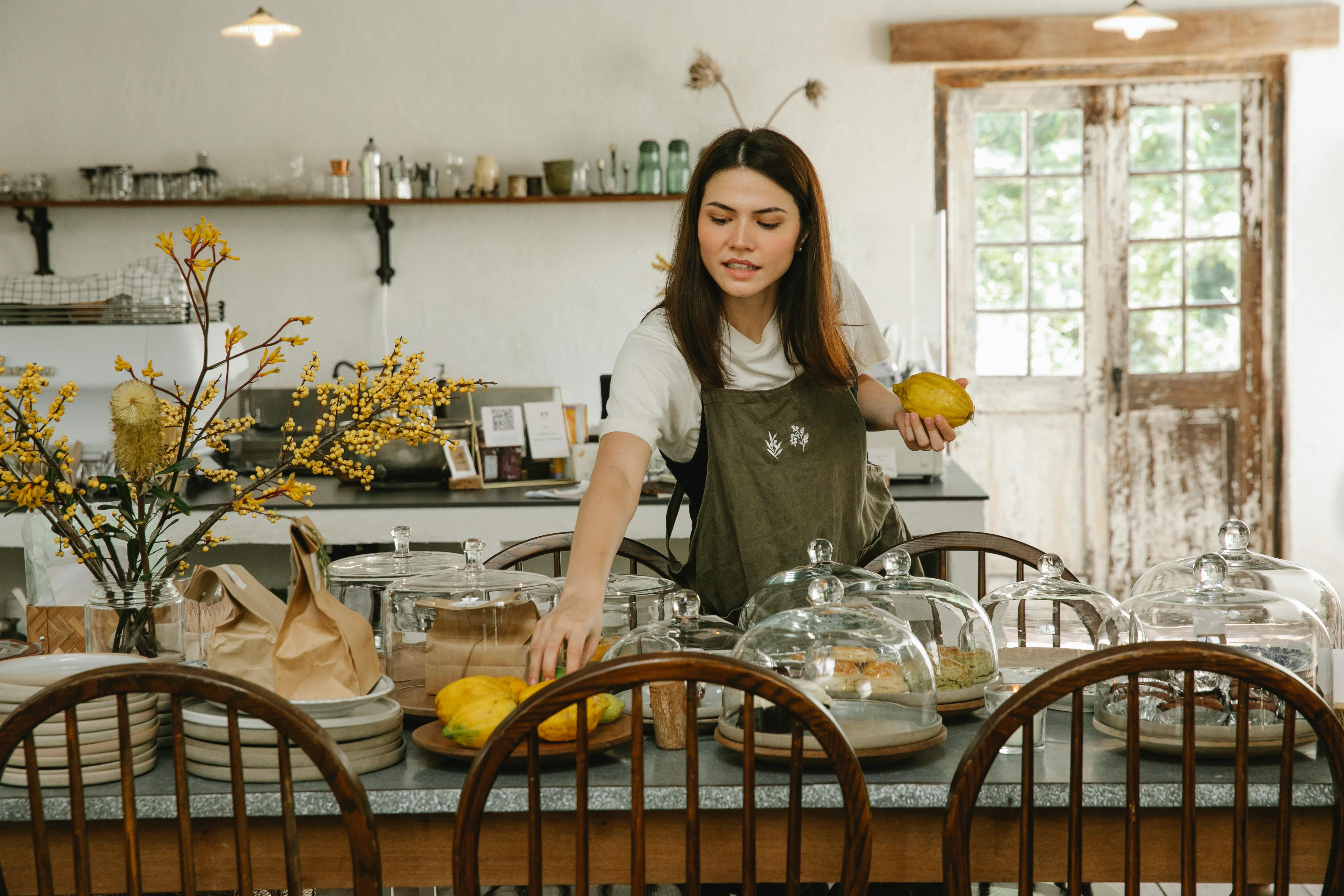 Focused waitress serving a table in a bakery.