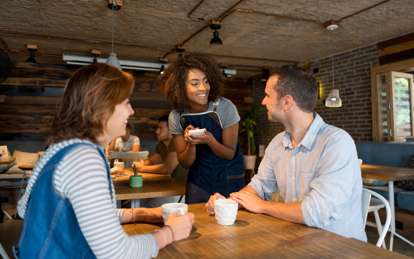 a small business owner warmly greeting a returning customer at a cafe or retail counter. Warm, human, community feel.