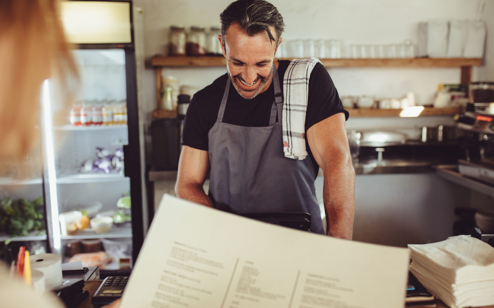 Staff at a newly scaled restaurant explains digital loyalty program to returning customer