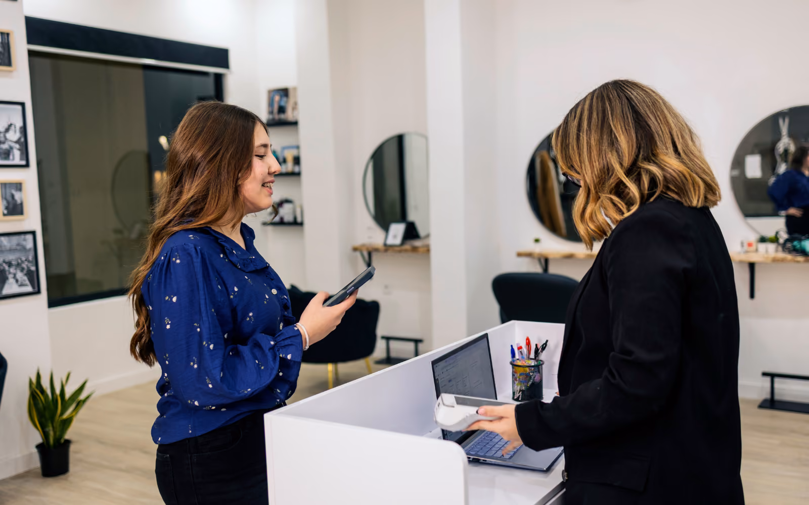 Customer using a digital loyalty card at an Australian beauty salon to encourage repeat visits and client retention.
