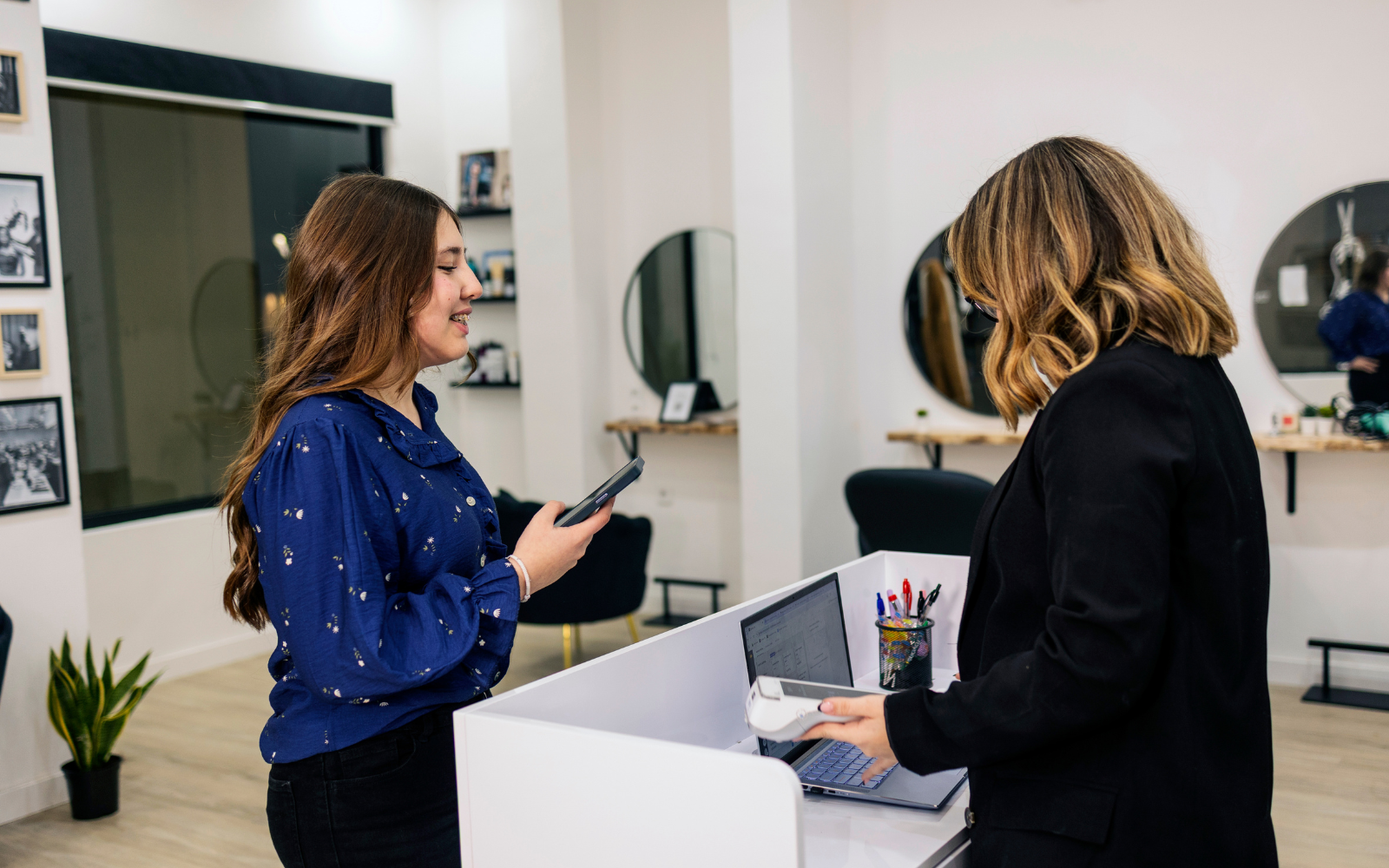Customer using a digital loyalty card at an Australian beauty salon to encourage repeat visits and client retention.