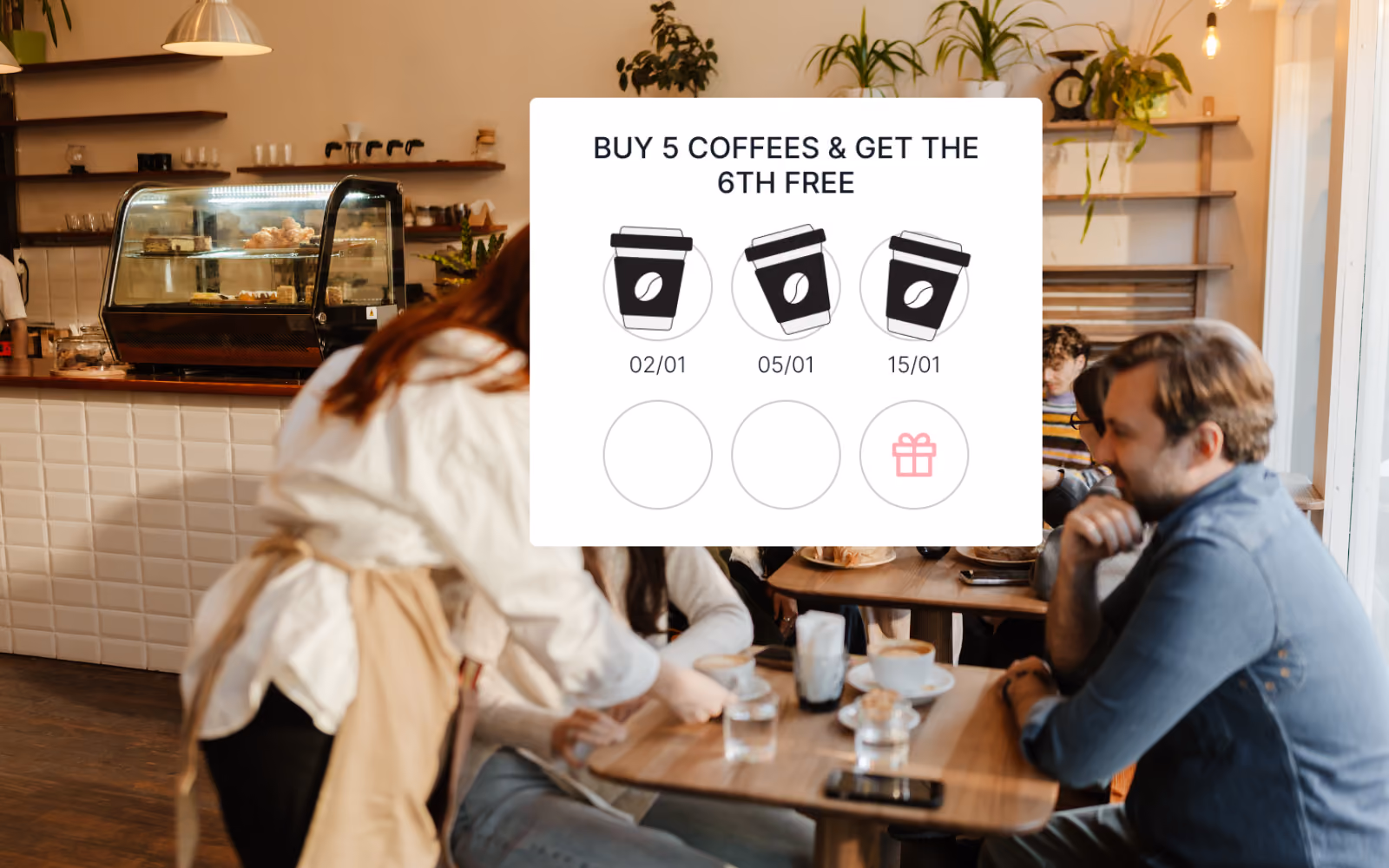 A cafe counter displaying both a paper loyalty stamp card and a digital loyalty rewards program on a tablet, illustrating the difference between traditional and modern customer retention tools for small businesses.