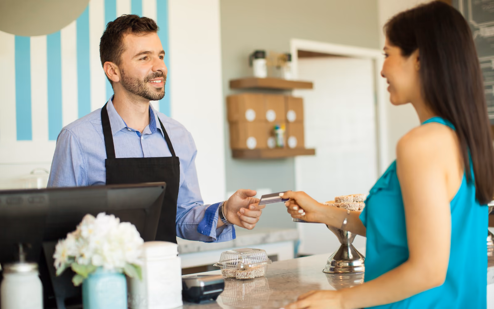 A small cafe owner reviewing customer loyalty program engagement data and redemption rates on a laptop, demonstrating how digital tools help track retention and repeat visit frequency.
