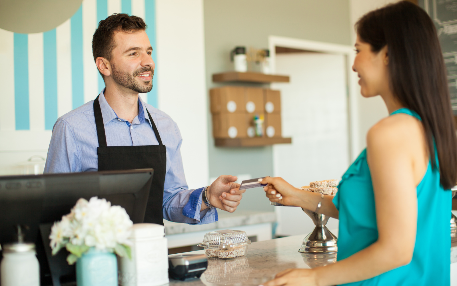A small cafe owner reviewing customer loyalty program engagement data and redemption rates on a laptop, demonstrating how digital tools help track retention and repeat visit frequency.