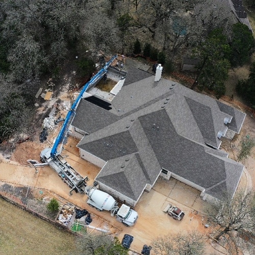 Aerial Photo of a Custom Luxury Home Concrete project handled by our team. The boom truck is set up to safely pour concrete from a far distance.