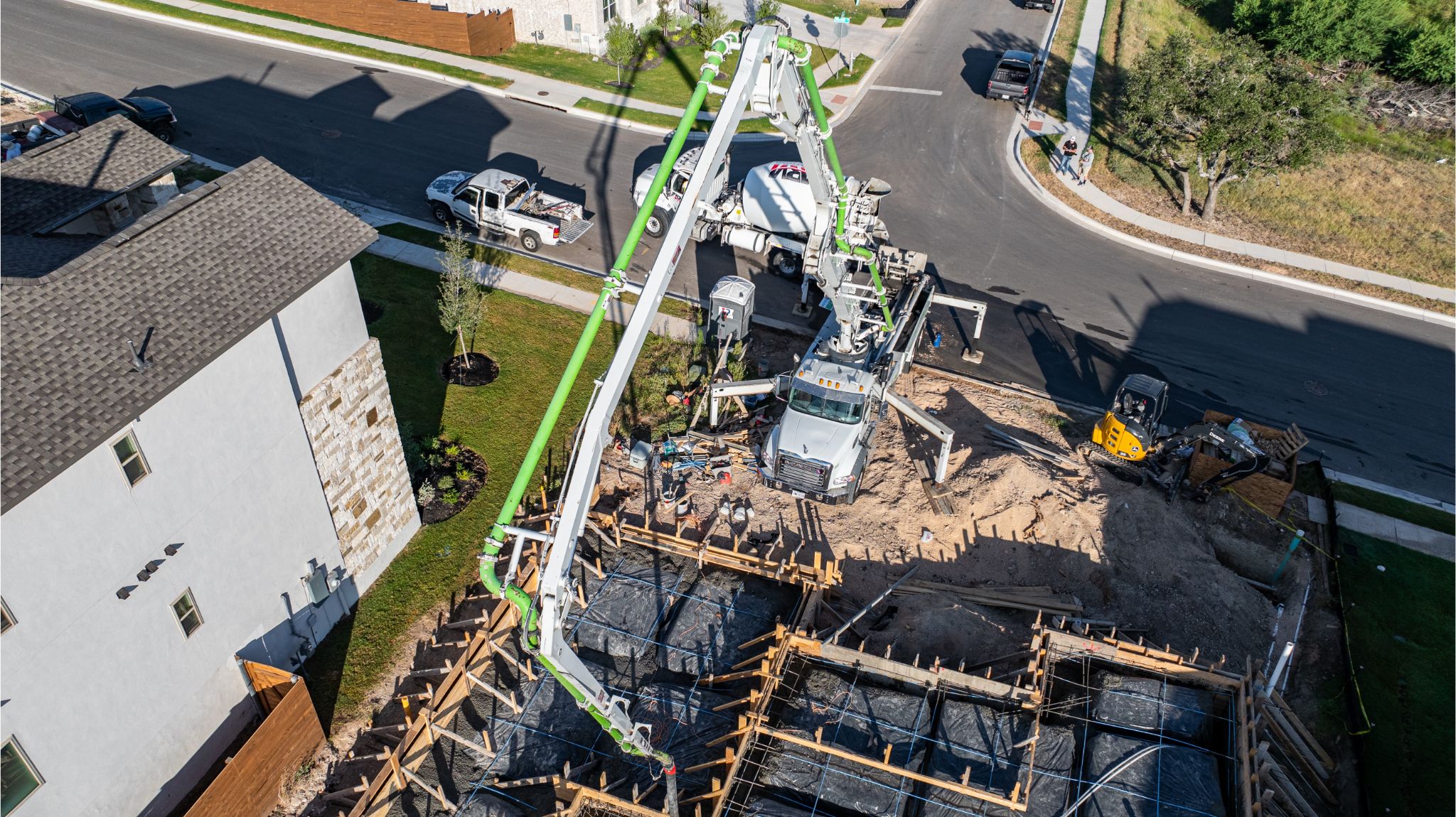 An Aerial Photo of  a Below-Grade Garage at one of Harrell Enterprises live projects. There is a boom truck that will be delivering concrete to it's designated location.