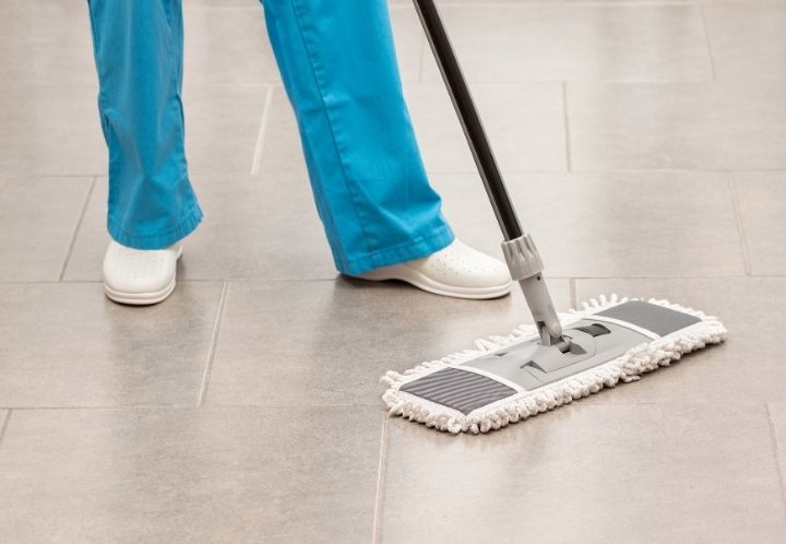 a person using a microfiber mop to sweep floor