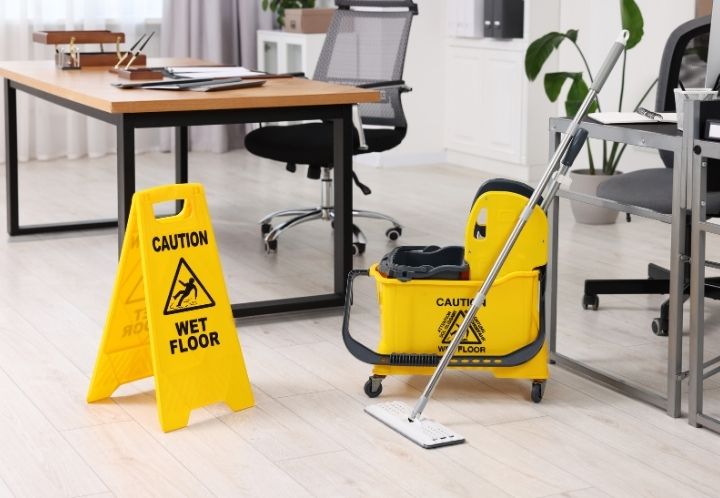 image of caution wet floor sign next to a mop