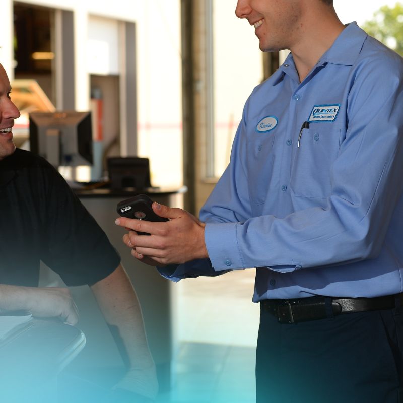 Quintex employee showing a customer something on their cellphone