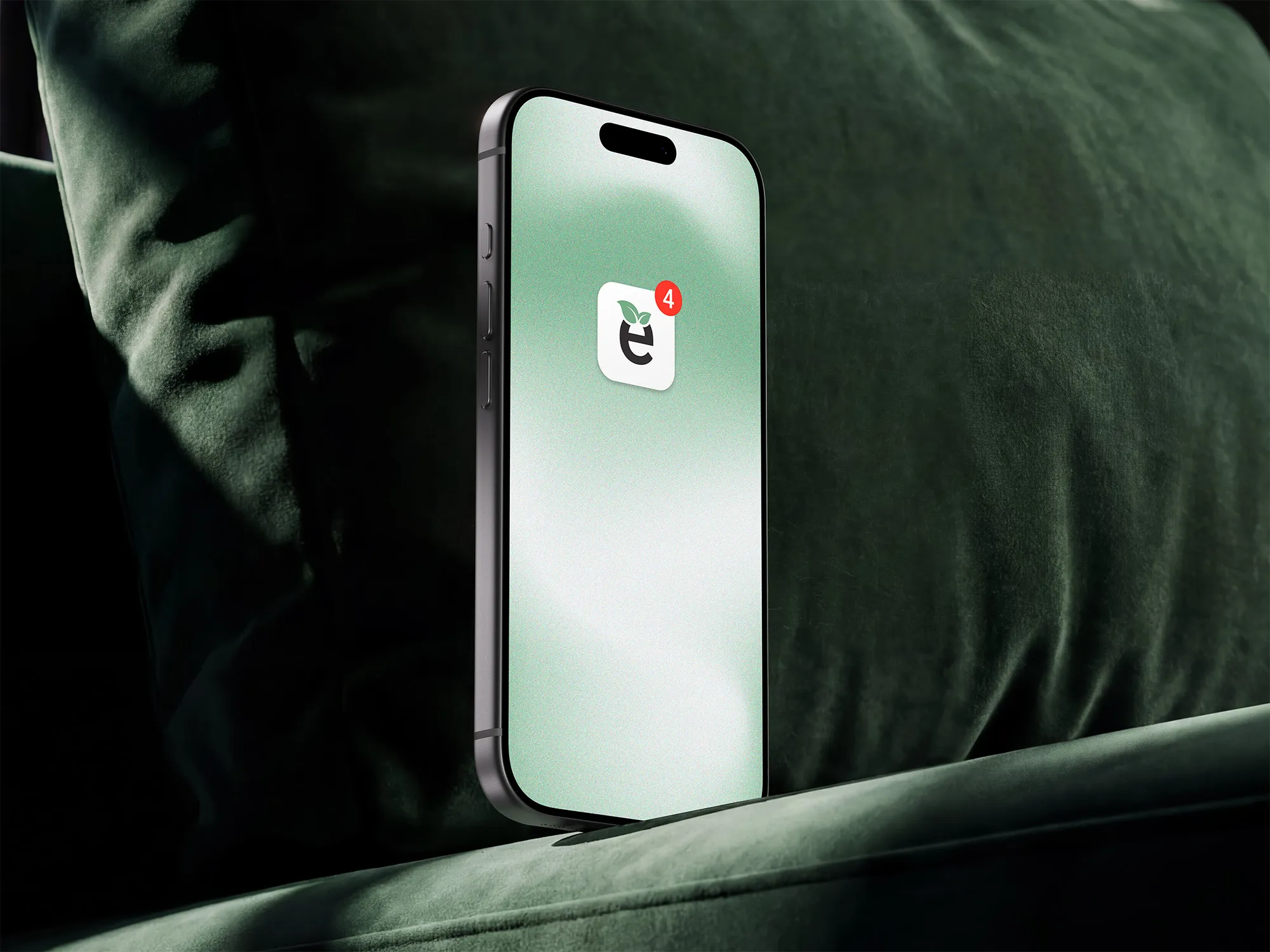 Ecovia clean-energy app icon with a notification displayed on a smartphone against a green velvet sofa.