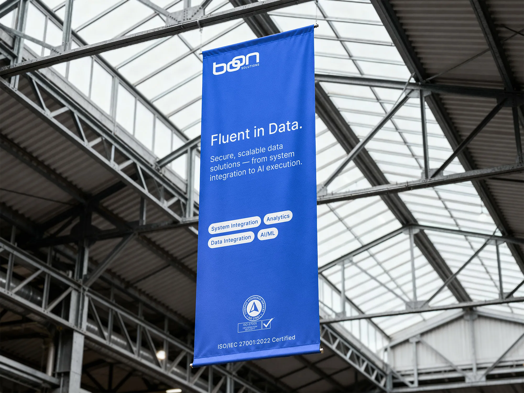 Blue Boon Solutions “Fluent in Data” banner suspended inside an exhibition hall.