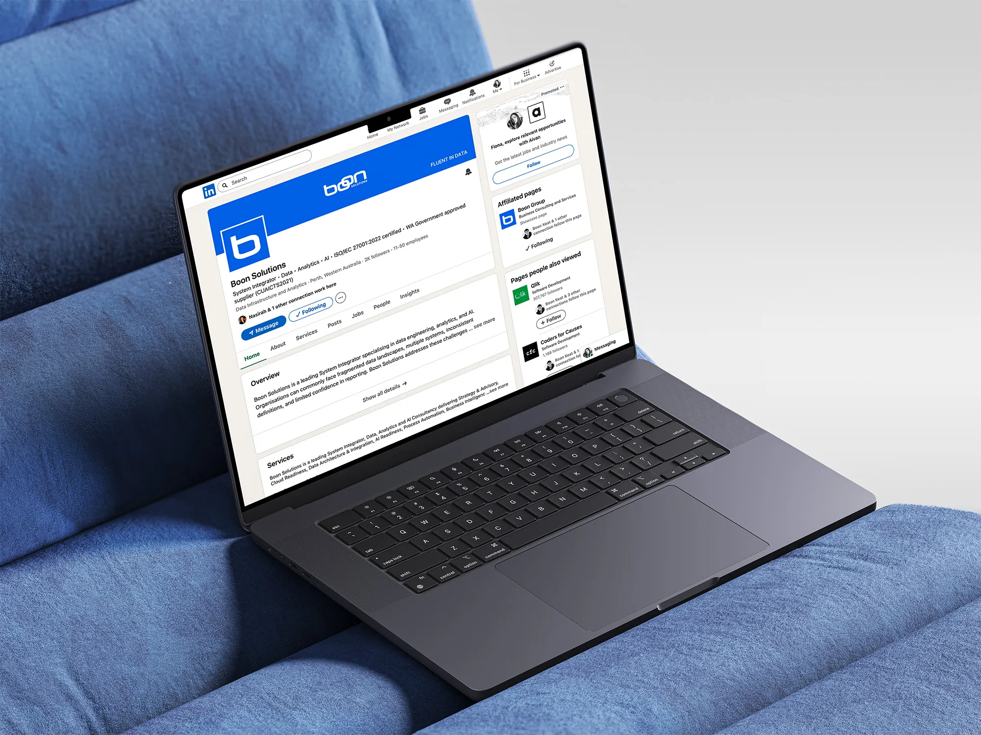 Boon Solutions branded LinkedIn company page displayed on a laptop on a blue sofa.