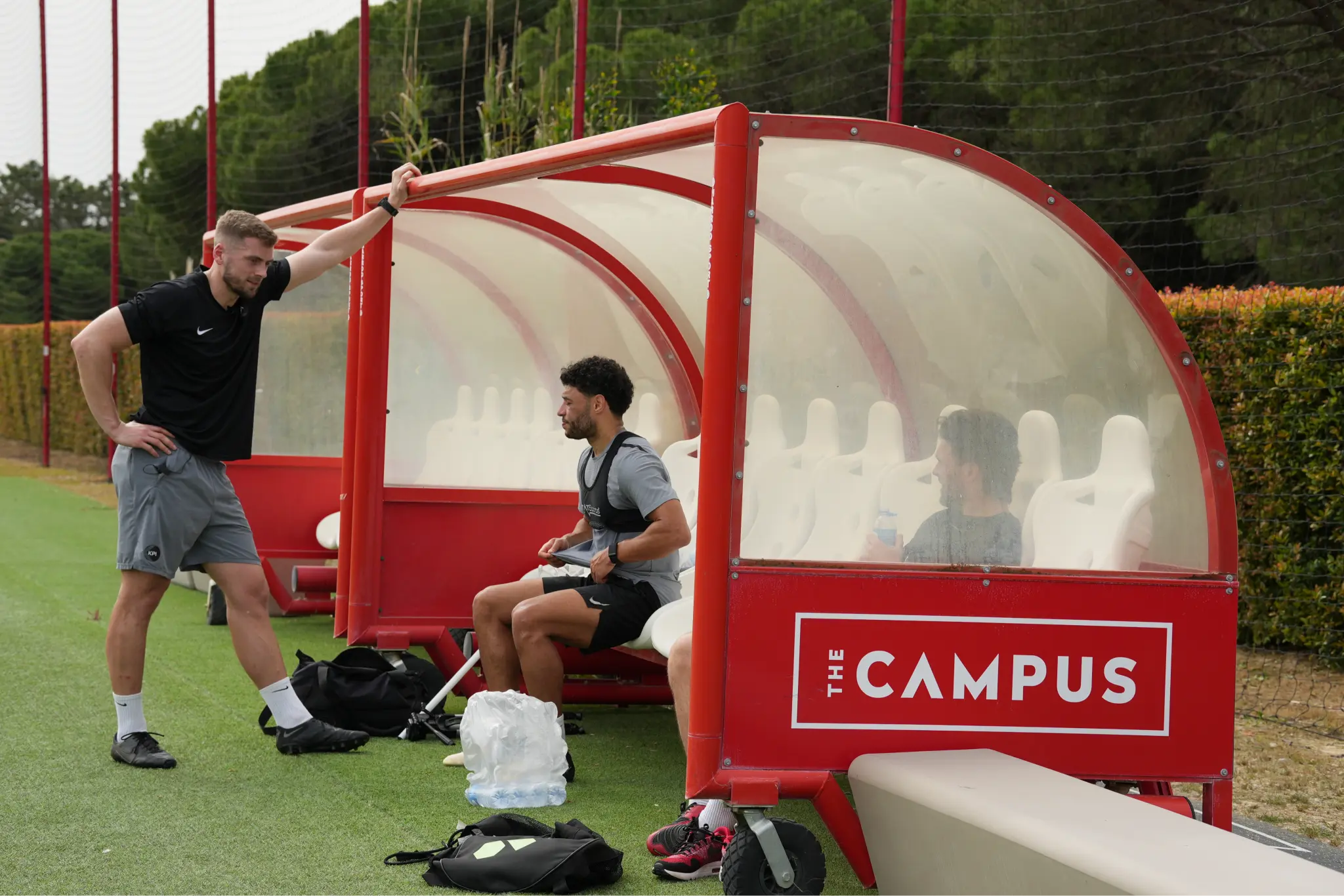 Two men in the coach bench near football field