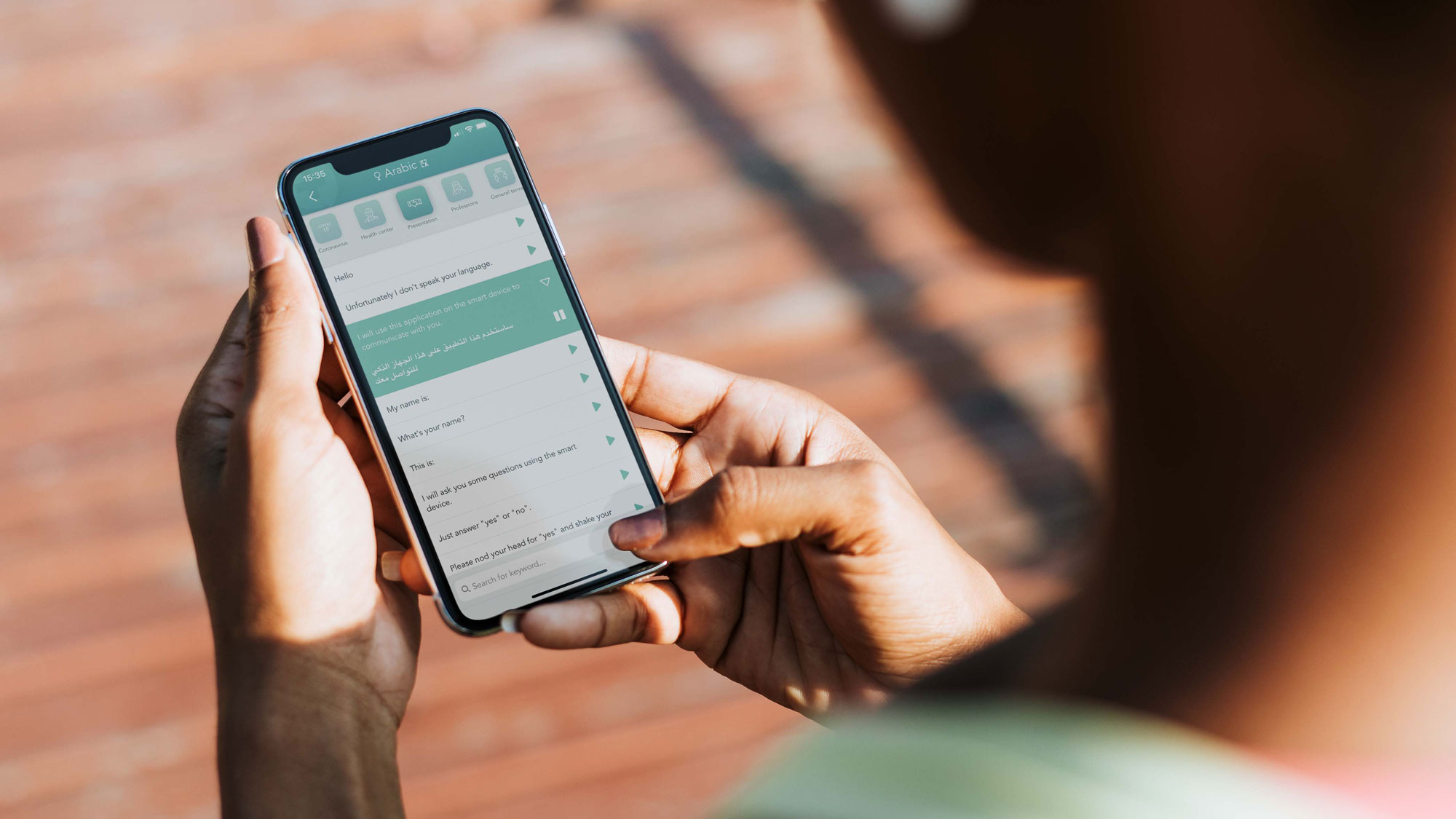 photo of a person holding a smartphone with the care to translate app on it