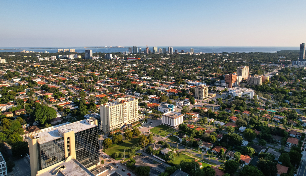 Aerial daytime view of Miami, Florida capturing city skyline and distant ocean.