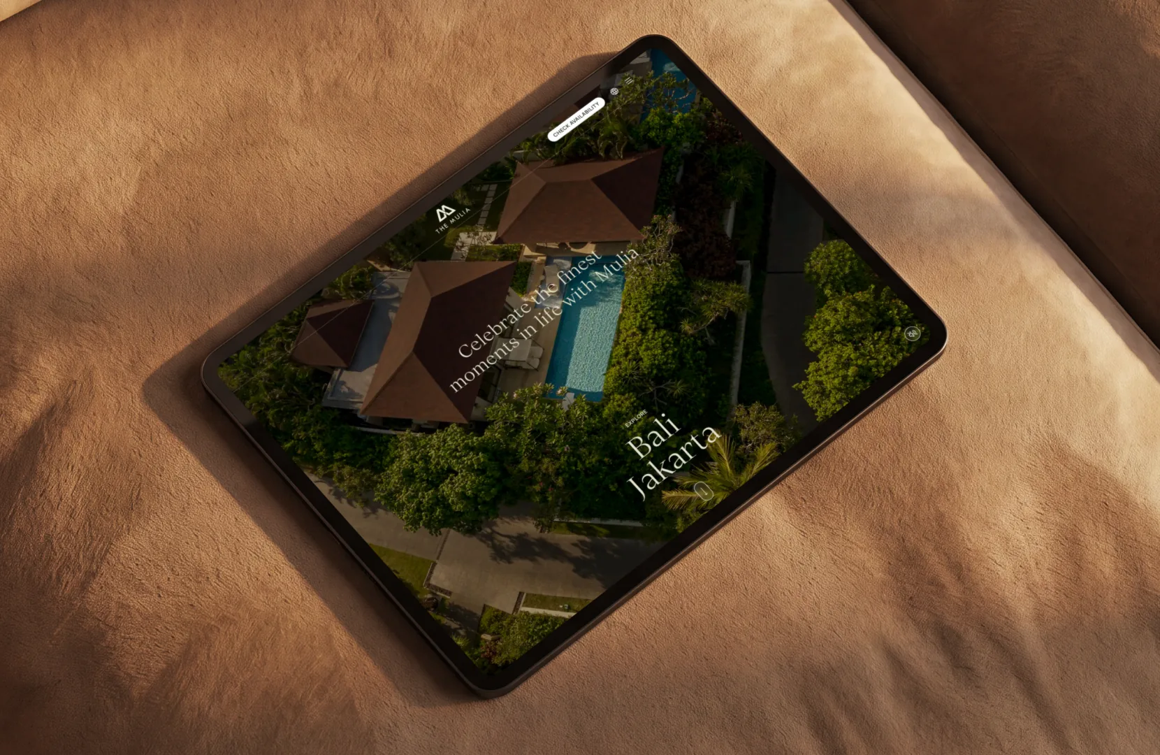 Resort website on a tablet resting on a leather sofa