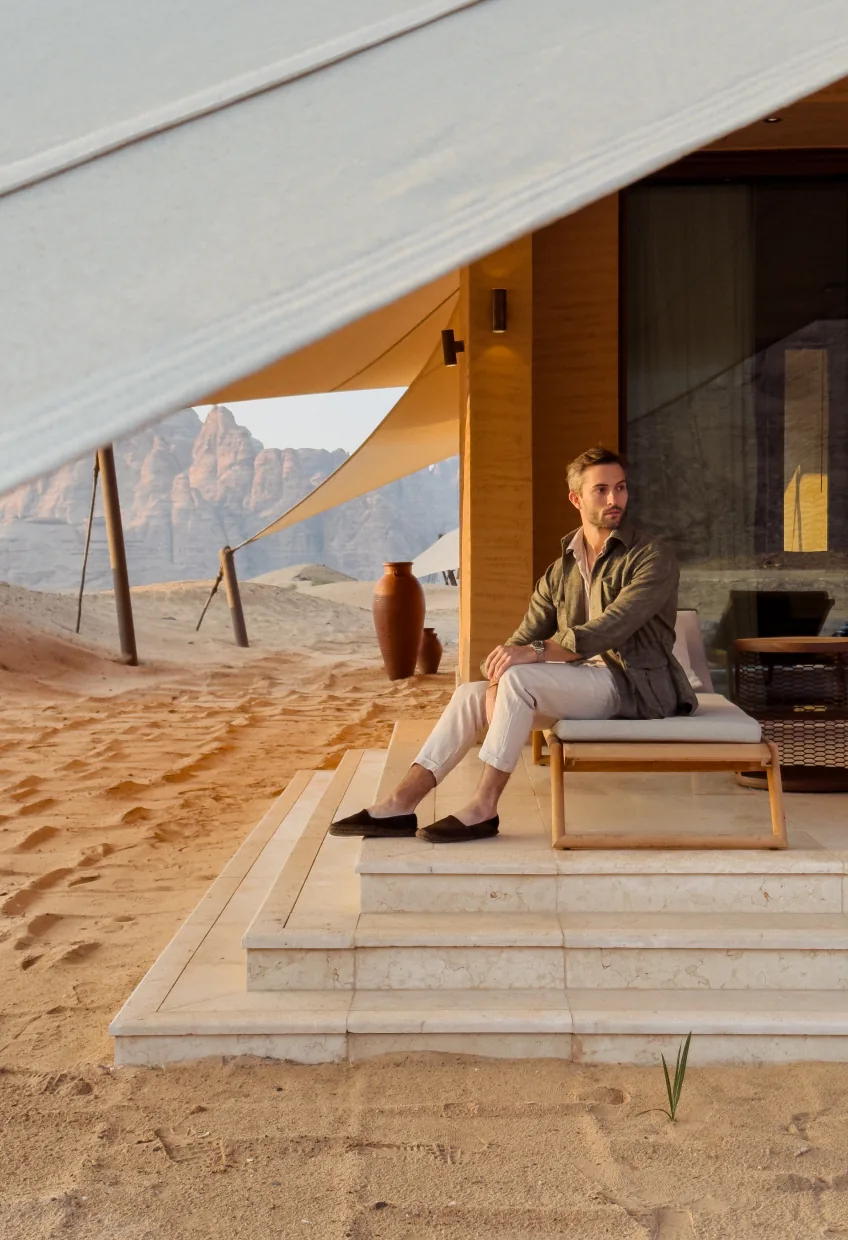 Guest relaxing on a tent terrace in the desert at Banyan Tree AlUla