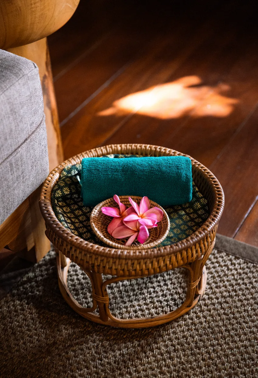 Rattan basket with a folded towel and frangipani at the spa, Banyan Tree Bintan