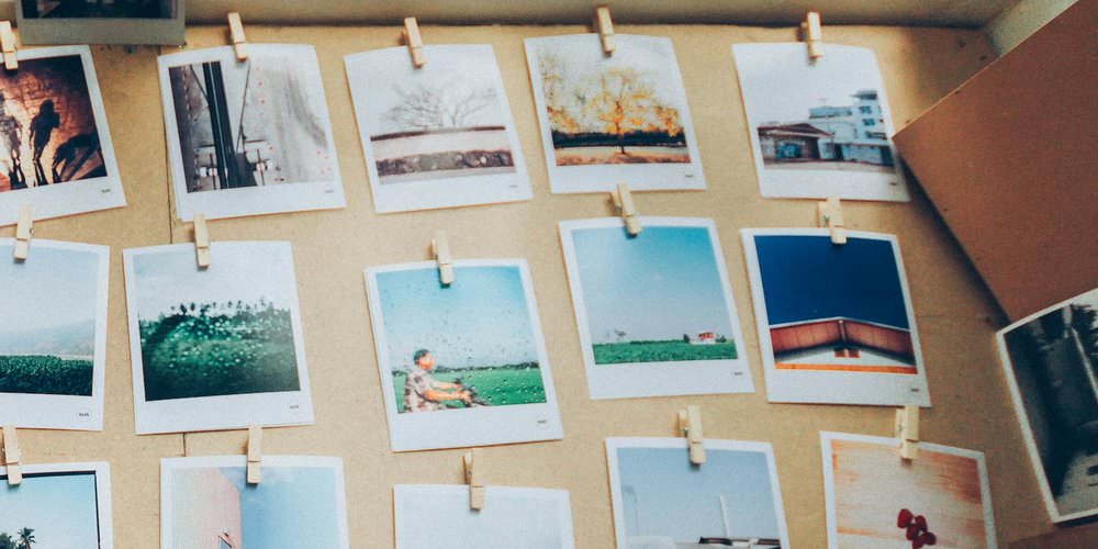 Instant photos clipped to a corkboard