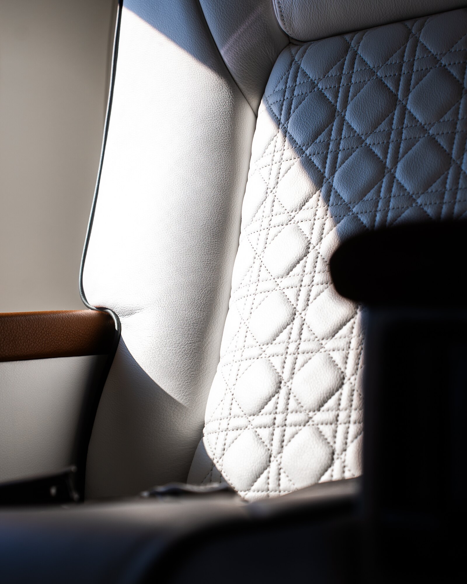 Cane-pattern quilted leather seat in window light — Gulfstream G-IV refurbishment by Avtec