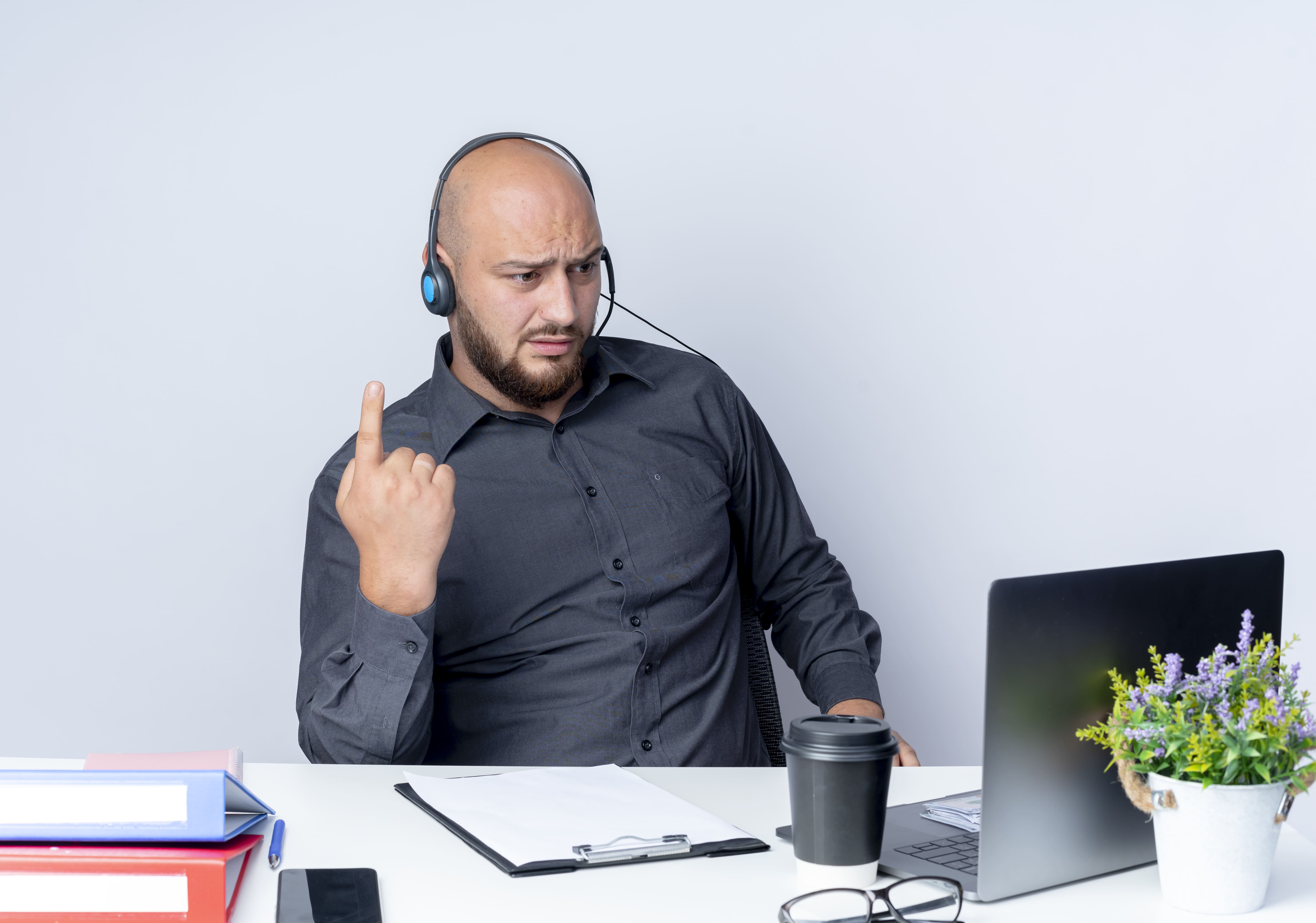 Frustrated sales representative wearing a headset, reacting to an unwanted recording bot during an online meeting