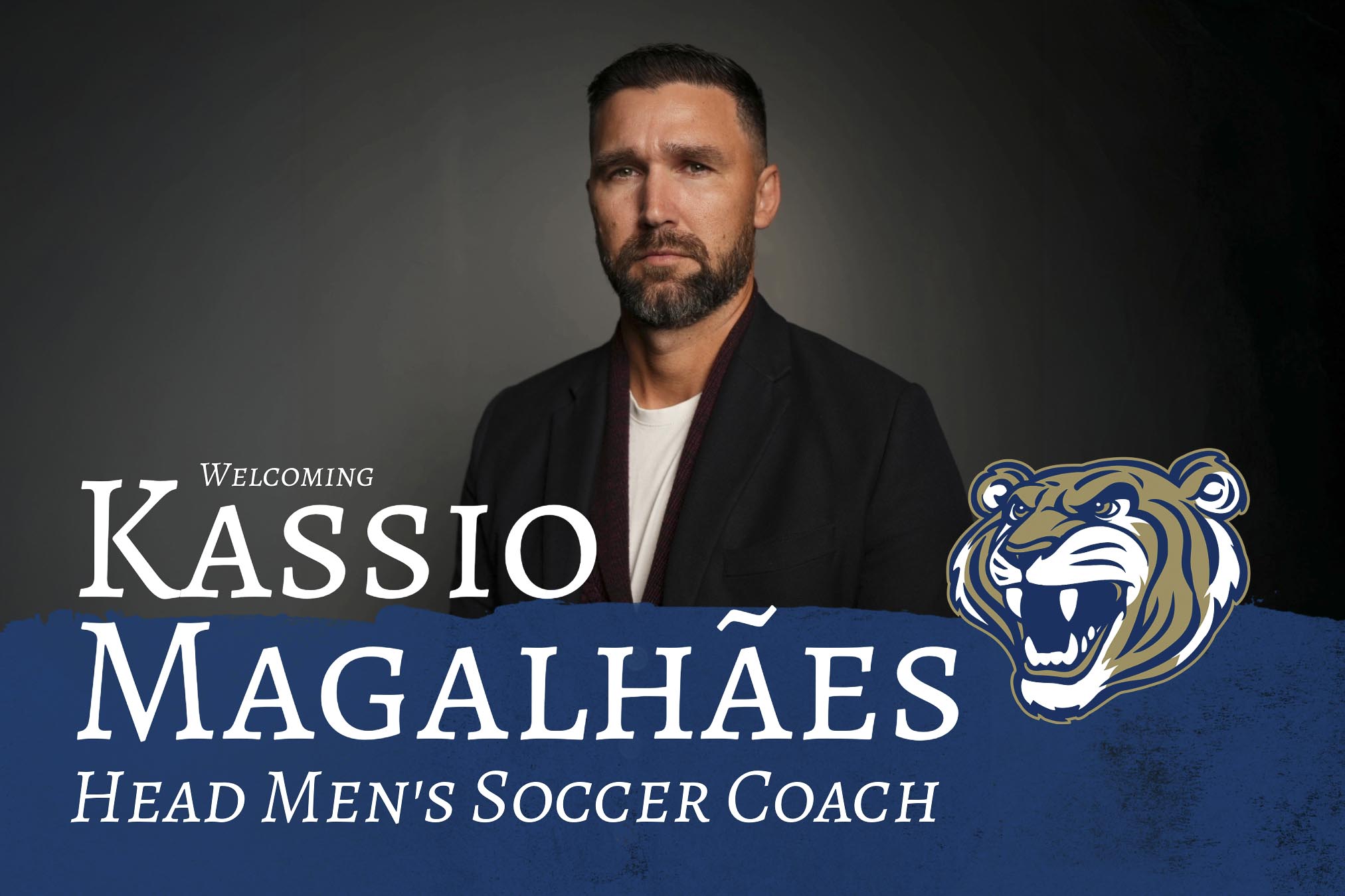 Coach Kassio smiling towards the camera in a black suit.