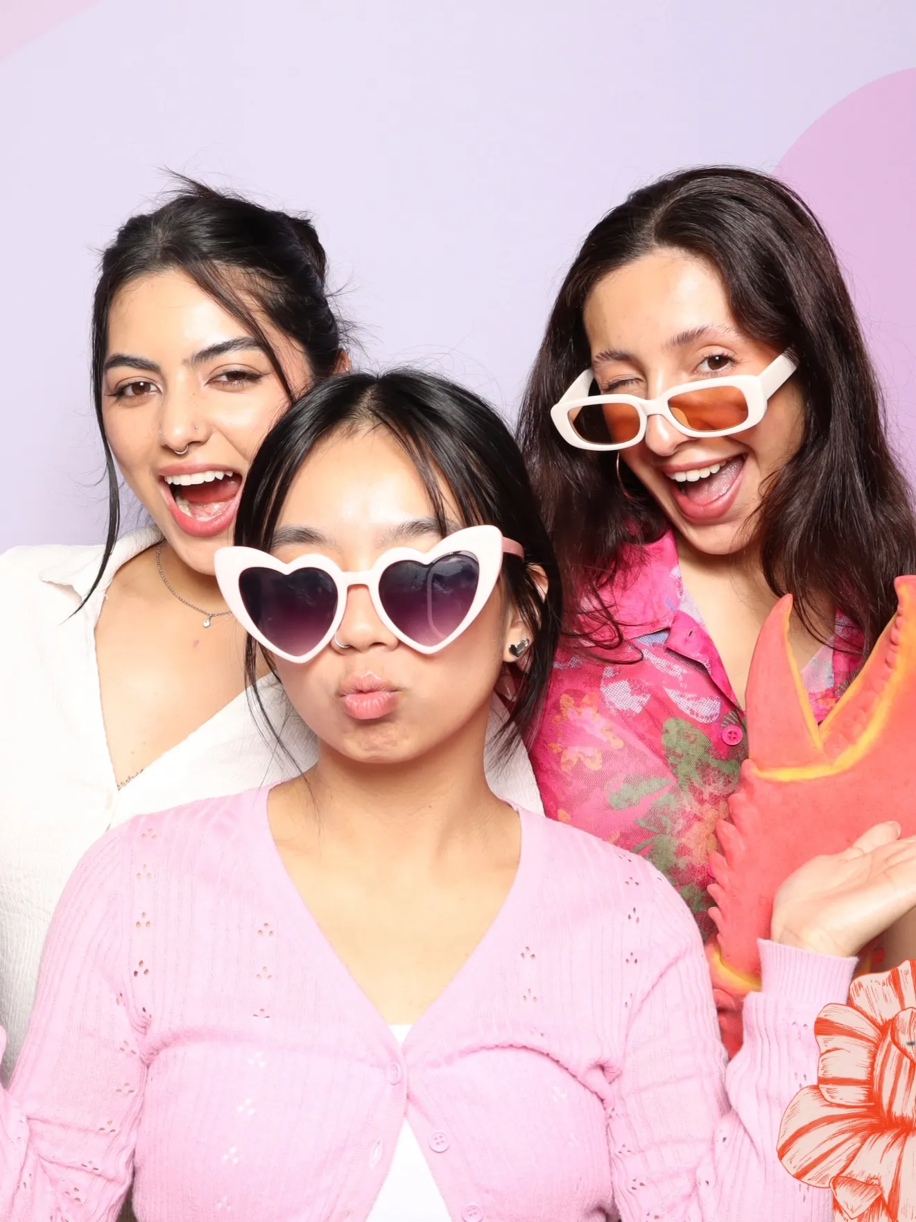 Studio booth rental at a winery in Oregon wine country with three people posing with fun props and a pink backdrop