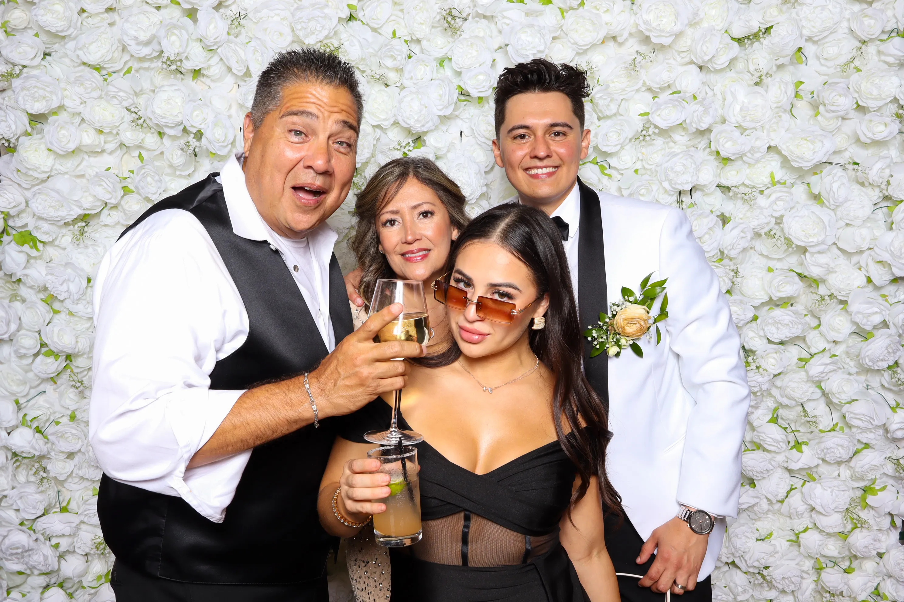 Portland, Oregon photo booth rental with festive guests at white flower backdrop
