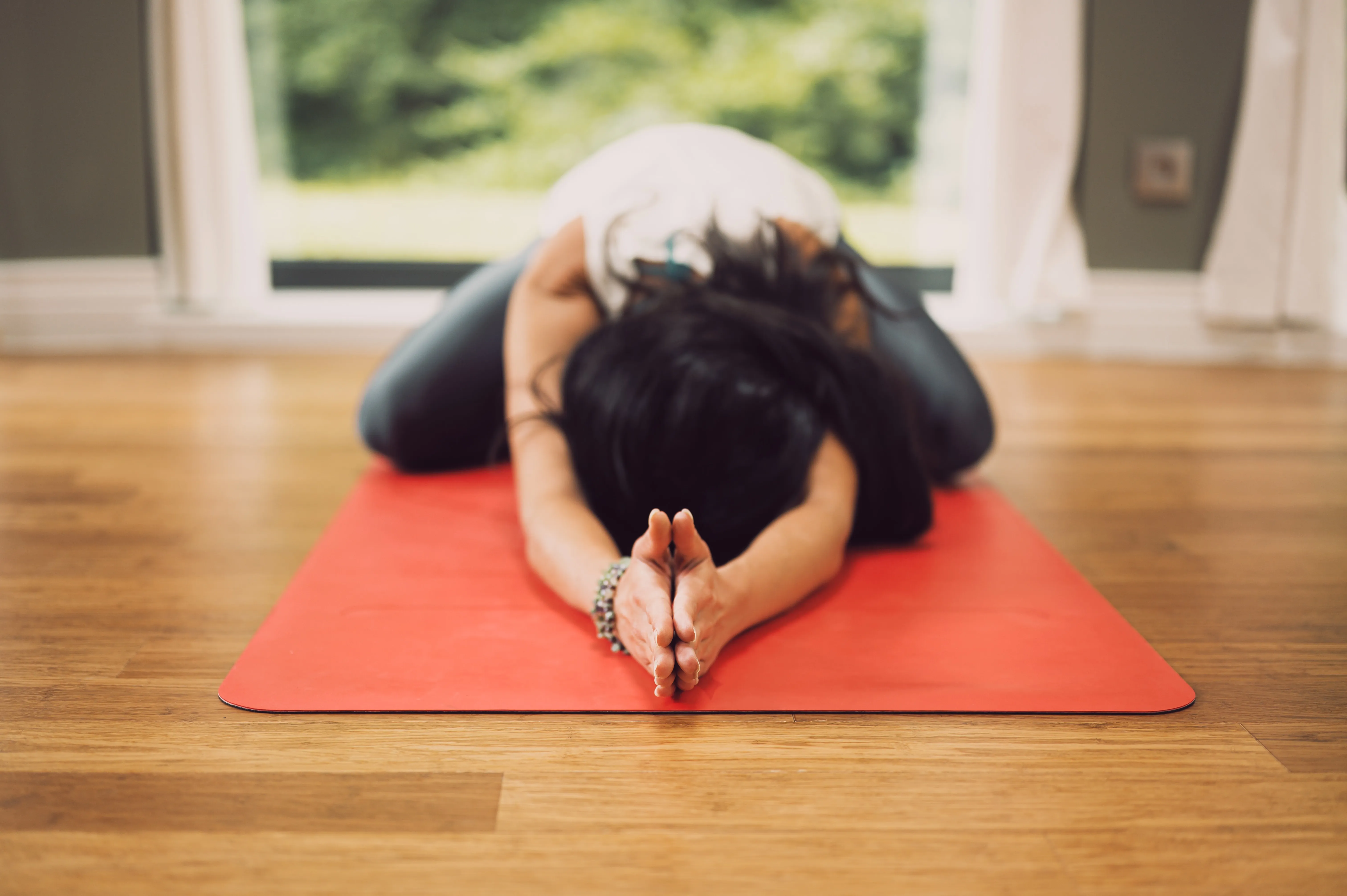 woman on an orange yoga mat in the child's pose