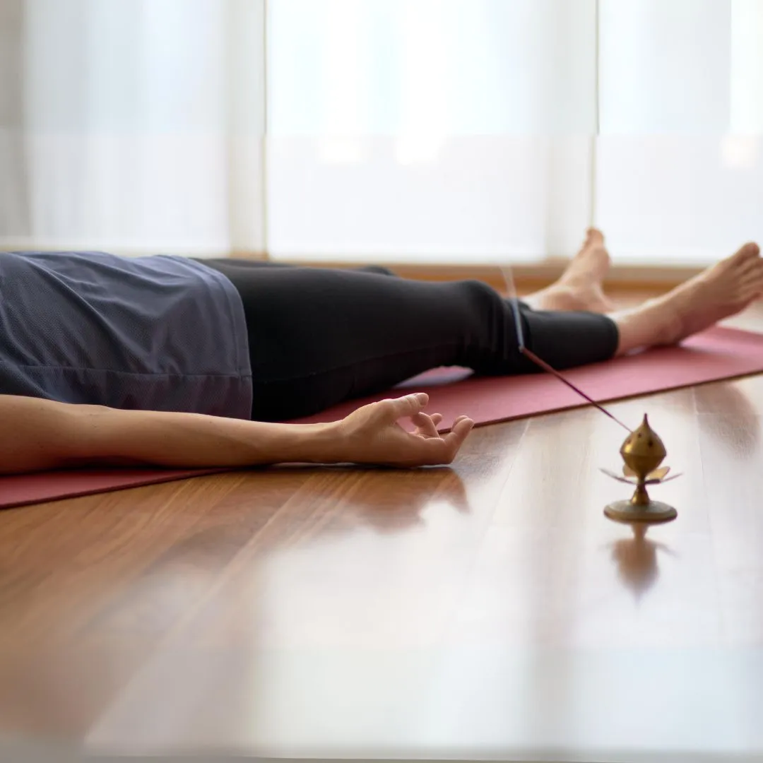 woman lying on the floor on a yoga mat
