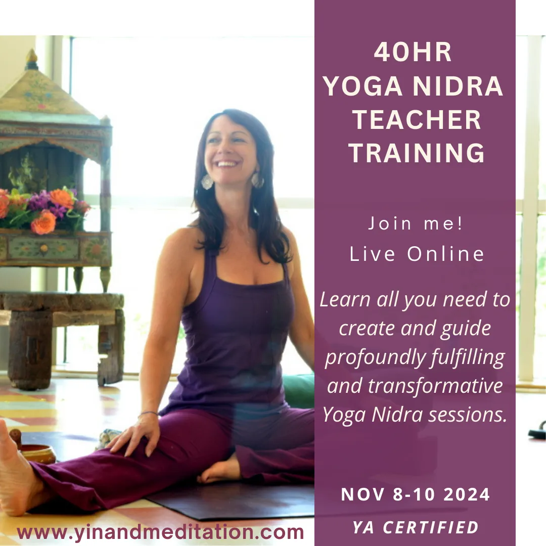 a picture of a yoga teacher smiling seated on a yoga mat