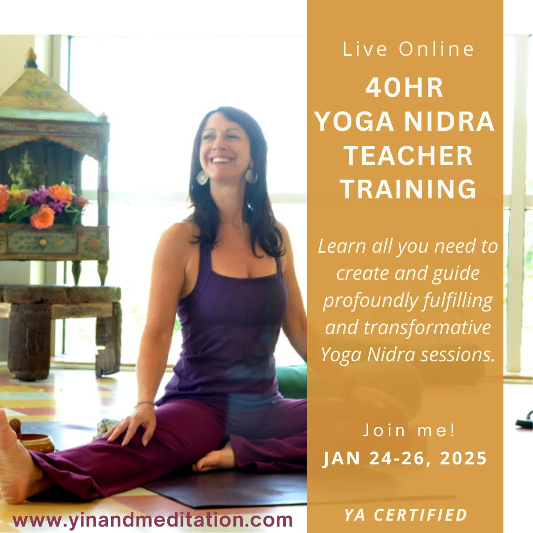a female sitting on a yoga mat smiling
