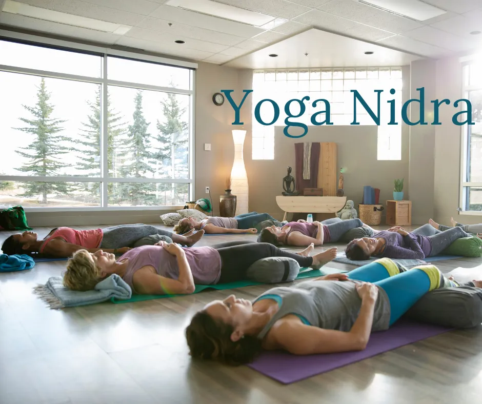 yoga students lying peacefully on their backs in savasana