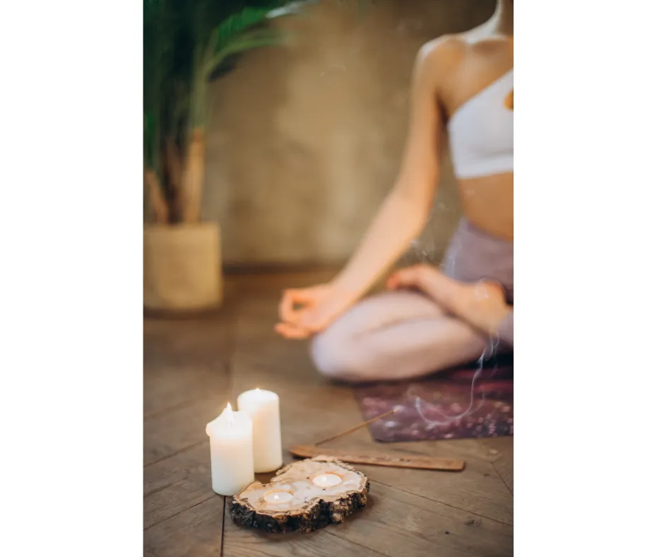 a female sitting in meditation posture with candles
