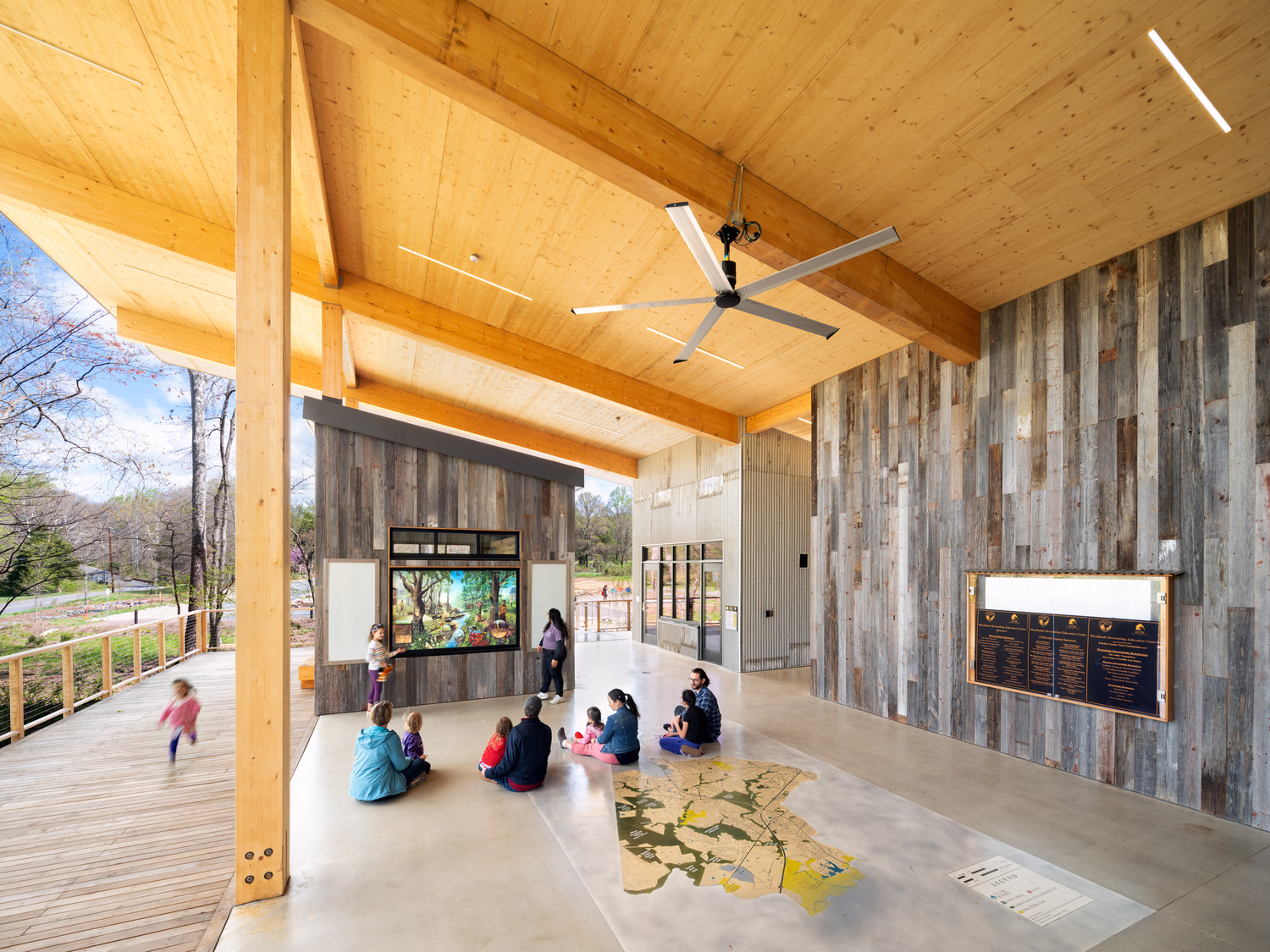 Visitors engage in educational material outside the Woodlands Stewardship Education Center.