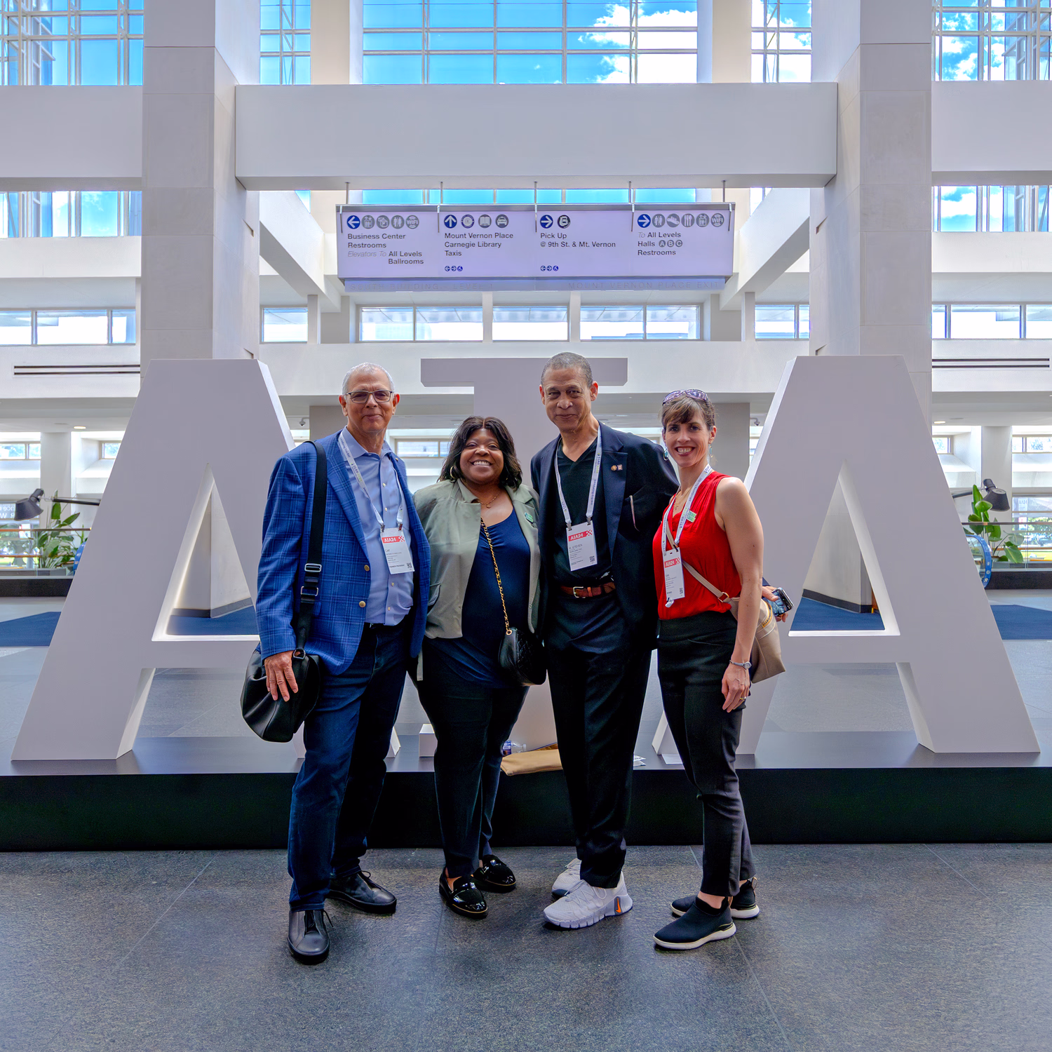 Team members stand in front of a large AIA sign.