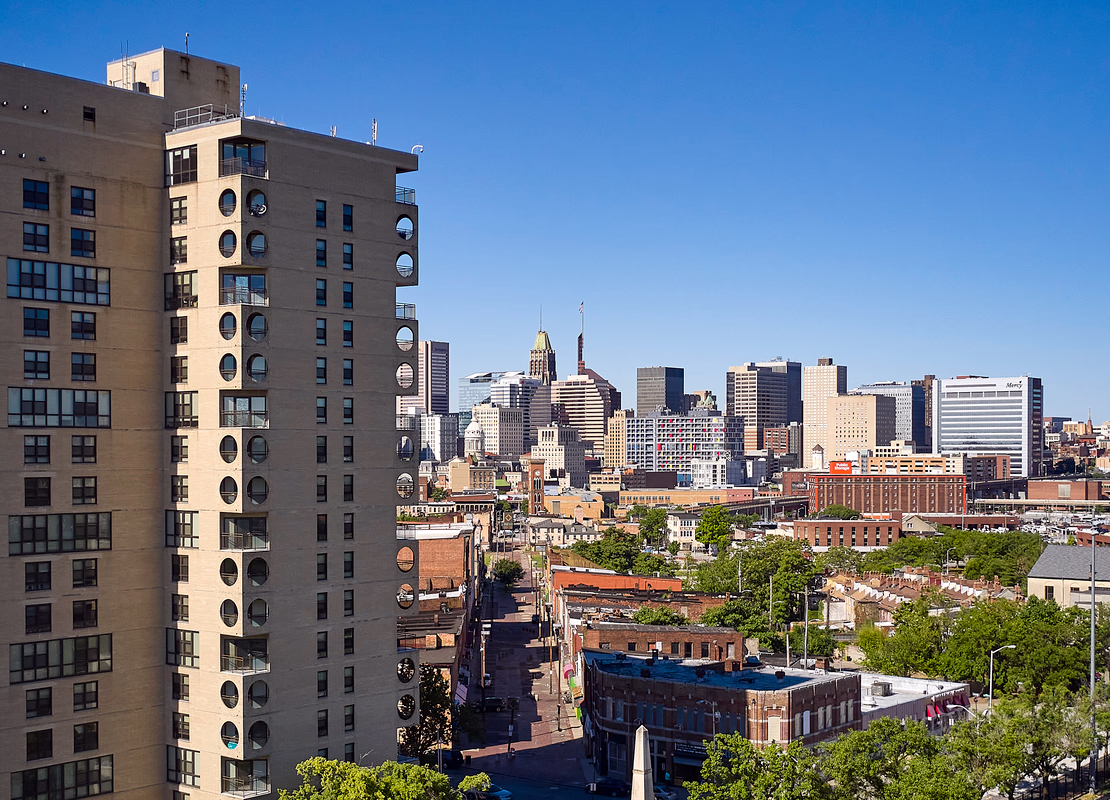 A building towers high above the others on the block on a bright day.