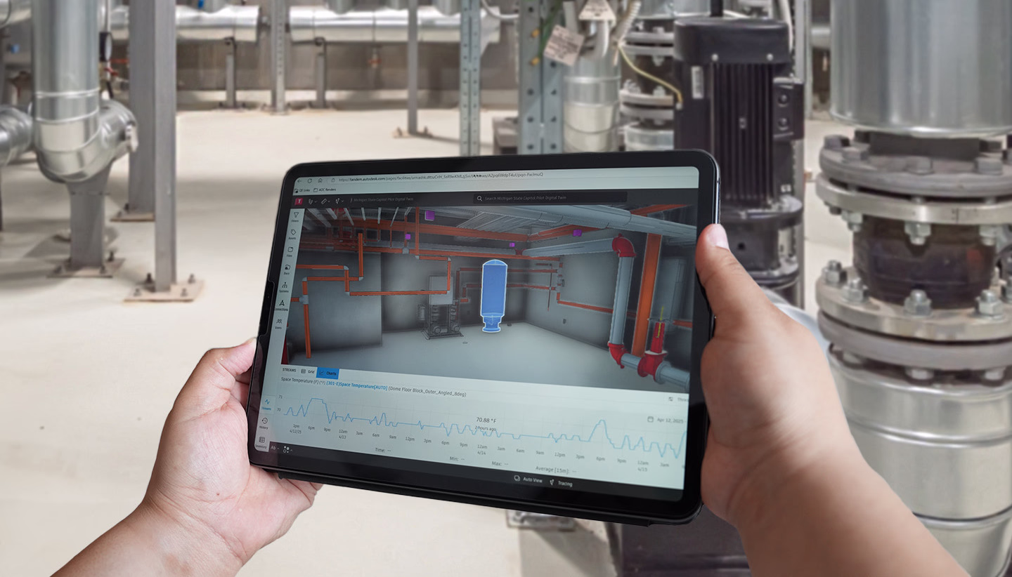Person holding tablet with digital twin on it in front of building mechanics.