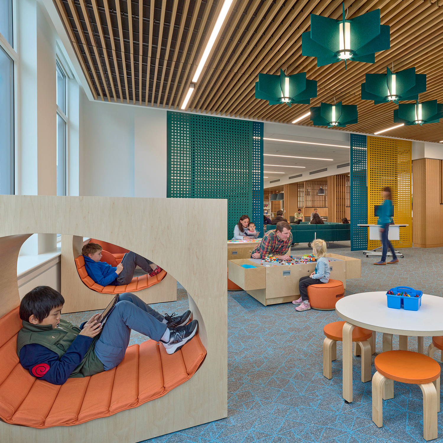 Interior of Johnston Square, Enoch Pratt Free Library. Families read and engage in activities.