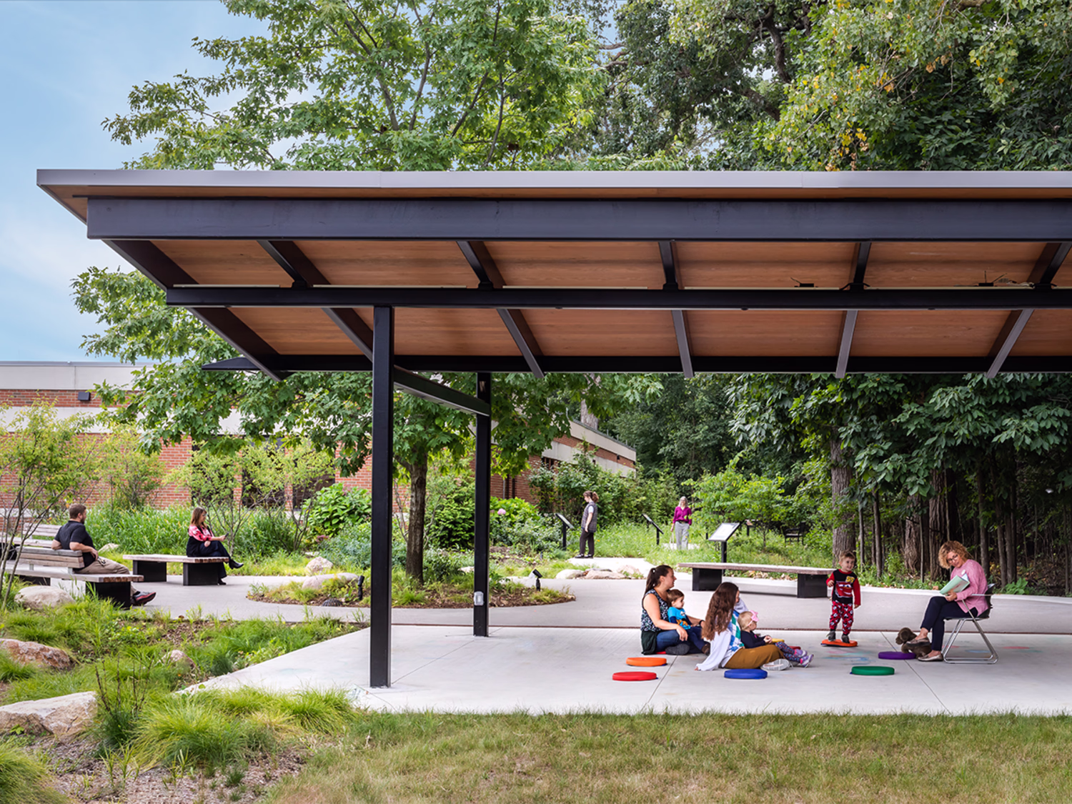 People walk along a ramp against a history building.