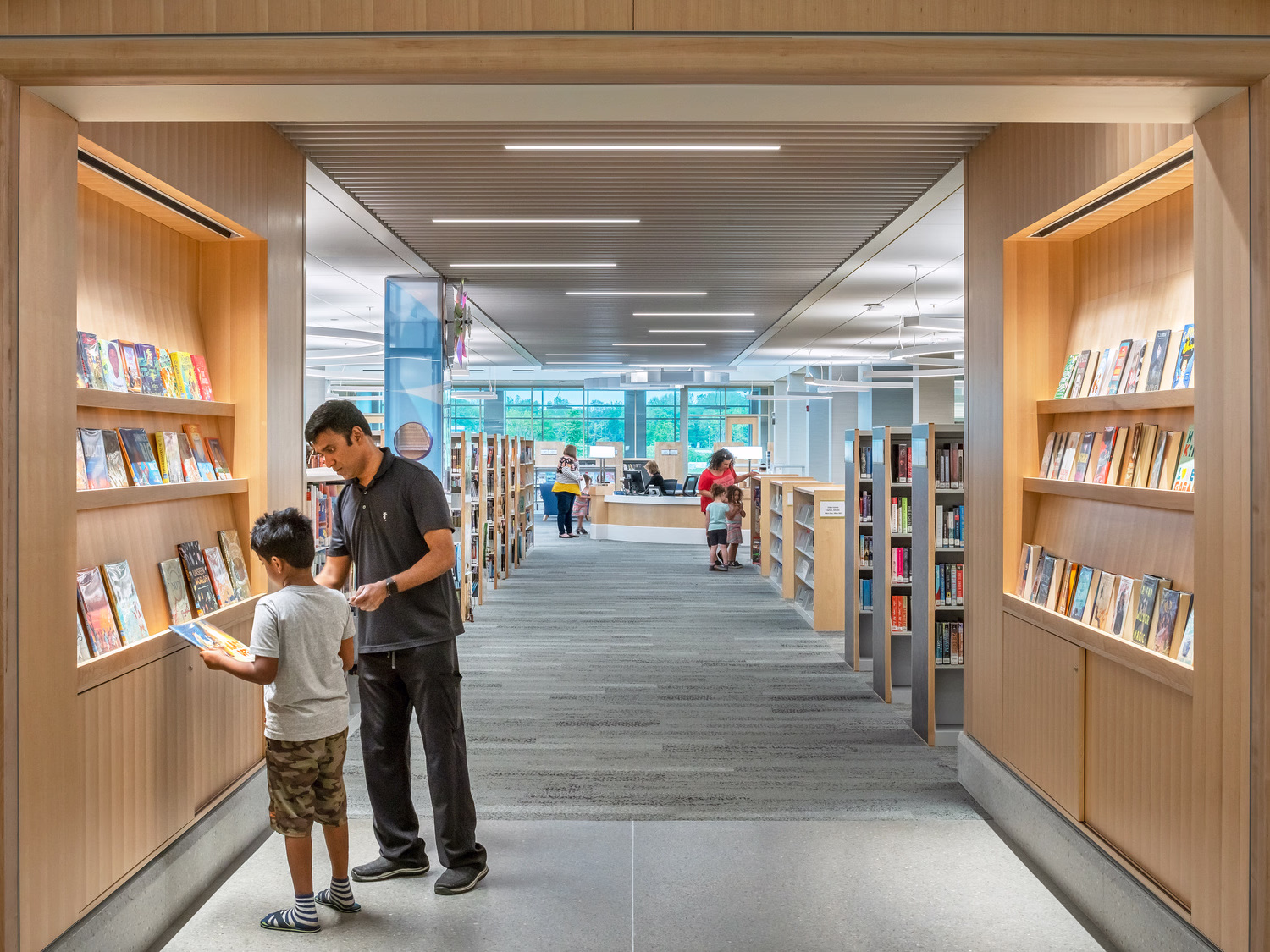 People walk along a ramp against a history building. 