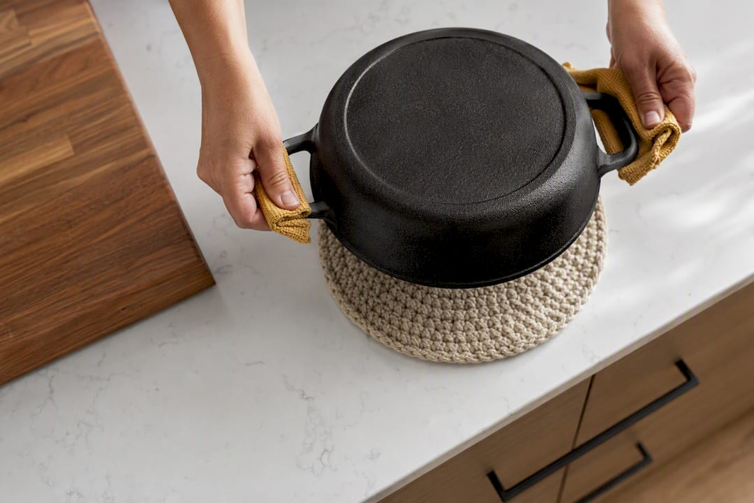 Cast iron pot resting on countertop trivet