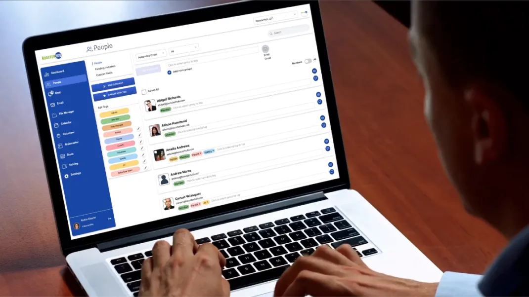 Person using a laptop displaying a software interface showing a people management dashboard with contact names, tags, and navigation menu on the left.