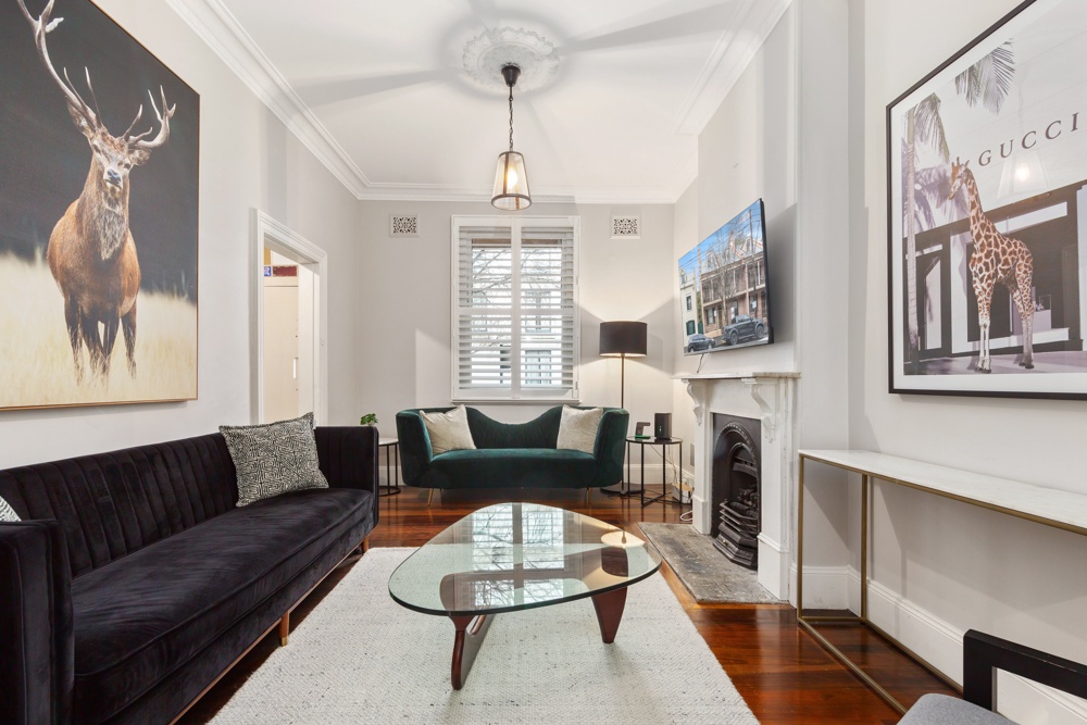 Living room with heritage fireplace and high ceilings in a four-bedroom Millers Point home