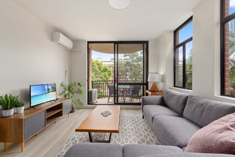 Furnished living room opening onto a balcony in a two-bedroom Pyrmont apartment