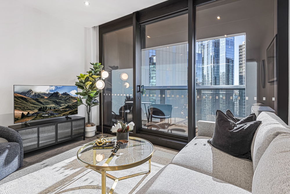 Living room and balcony of a MadeComfy two-bedroom apartment in Southbank