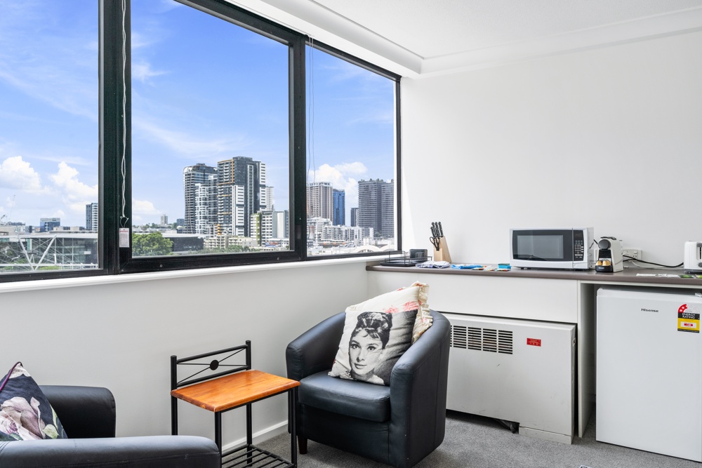 Sitting area and kitchenette in a MadeComfy Brisbane City studio overlooking the river