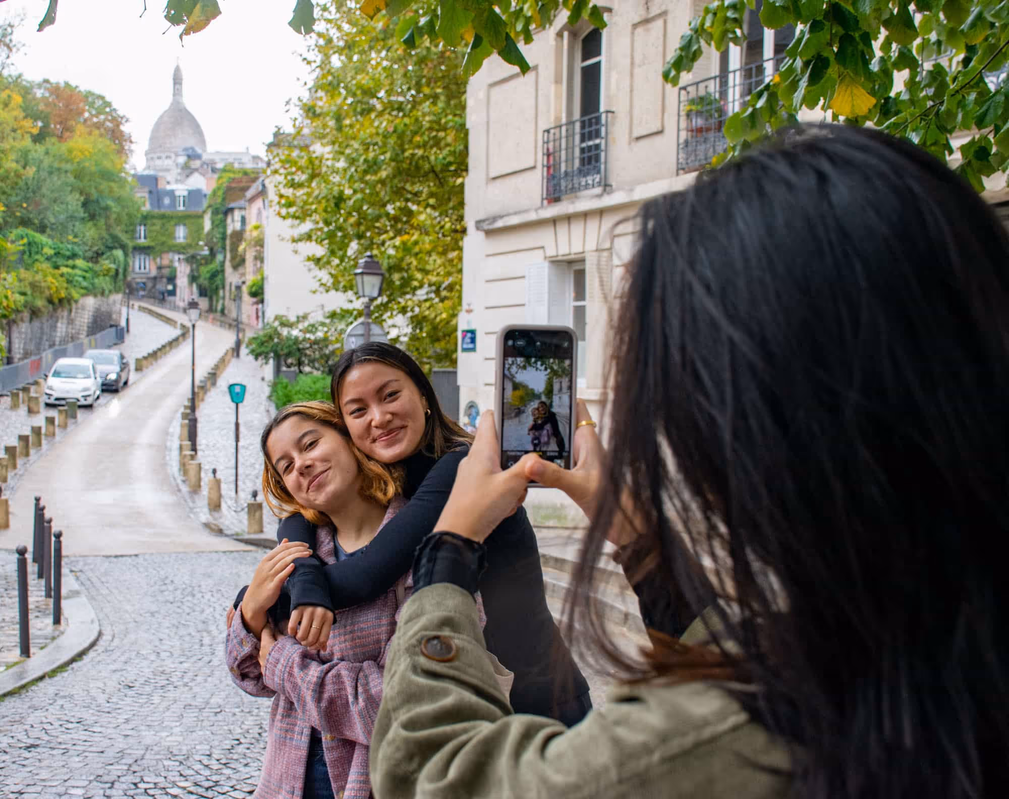 3 girls taking photo in front of Sacré Coeur in Montmartre, Paris - Dayin Guided Tours