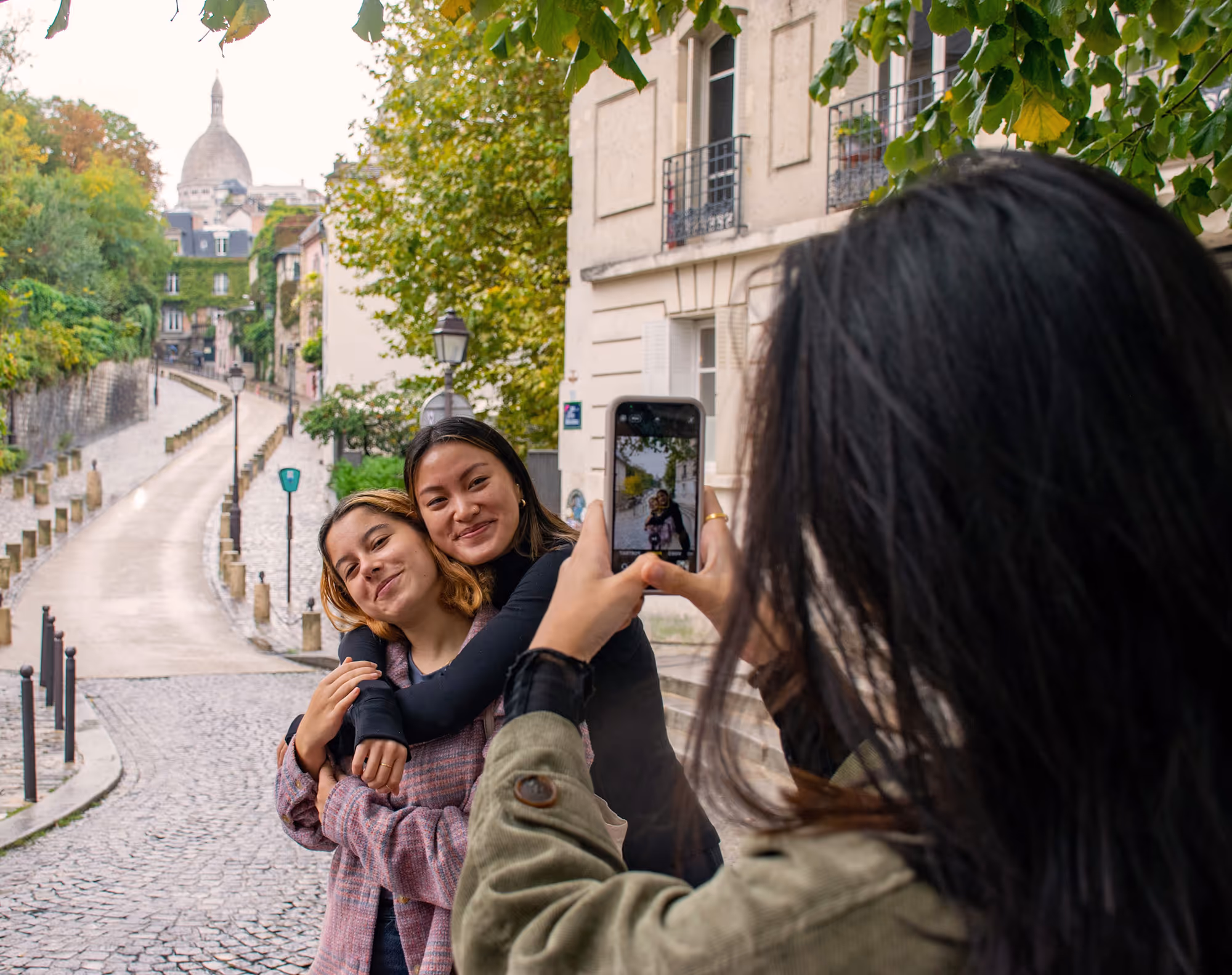 Happy group of three girsl taking photos in Montmartre