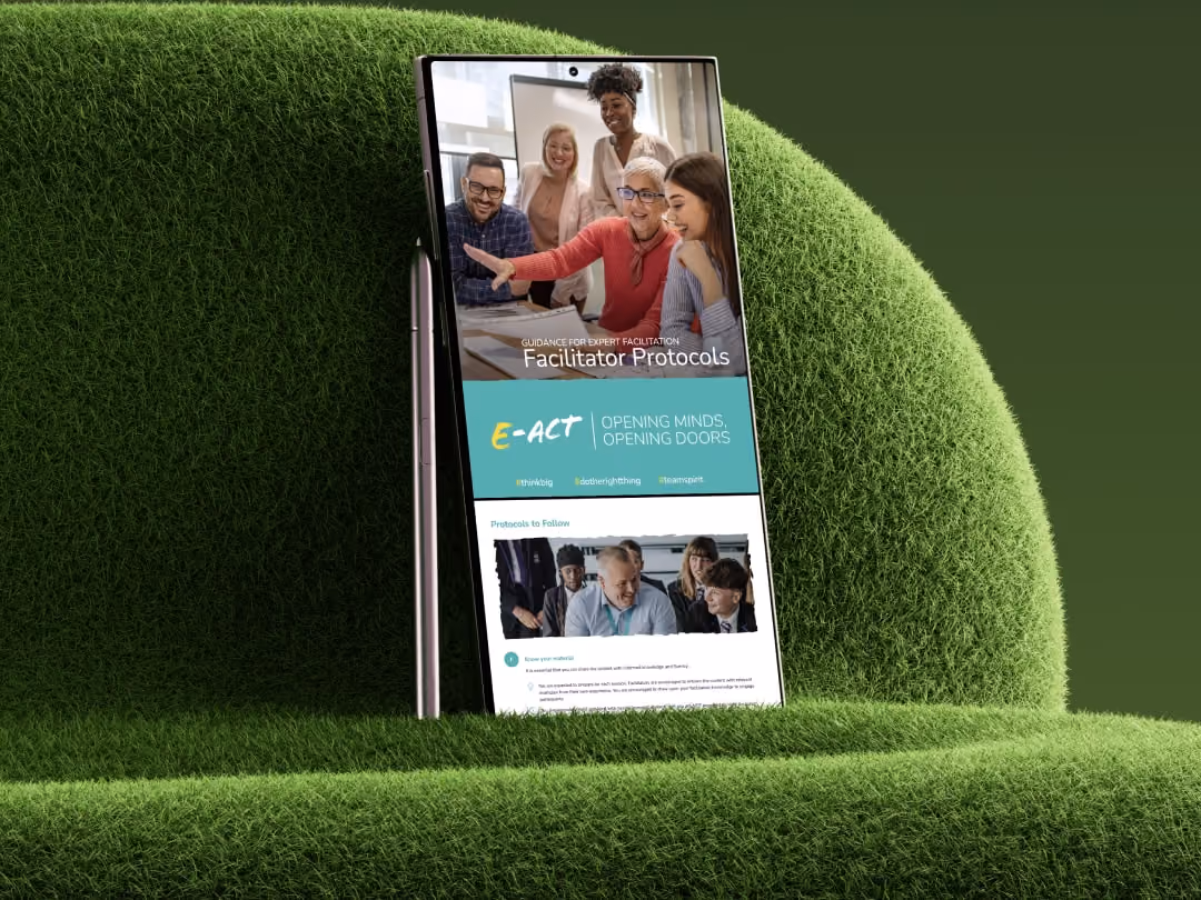 Smartphone on green textured surface showing an online facilitator protocols guide with diverse team photo.